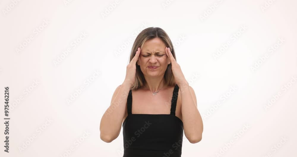 Irritated woman touches head experiencing acute pain on white background. Blonde female in dress puts palm on forehead suffering from headache Irritated woman touches head experiencing acute pain on white background. Blonde female in dress puts palm on forehead suffering from headache