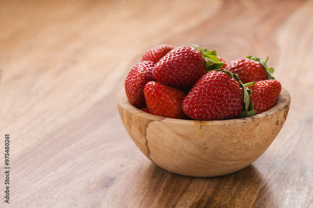 Ripe strawberries in wooden bowl on wood background with copy space Ripe strawberries in wooden bowl on wood background with copy space