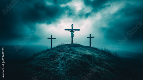 Dramatic Silhouette of Crucifix on Hill Against Moody Sky photo