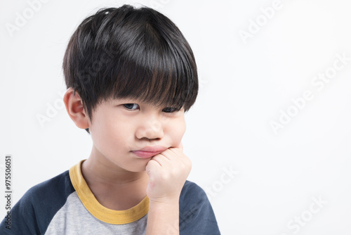 Close-up of a bored or thinking Thai boy resting his chin on his fist against a plain white background.