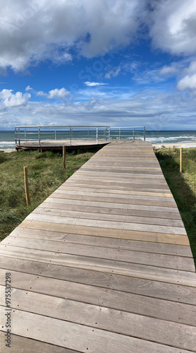 vertical panorama view of wooden boardwalk over dunes to lookout on top of Atlantic wall photo