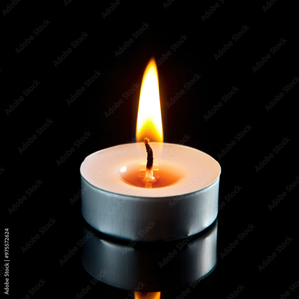 Front view of little burning candle on black Front view of little burning candle on black
