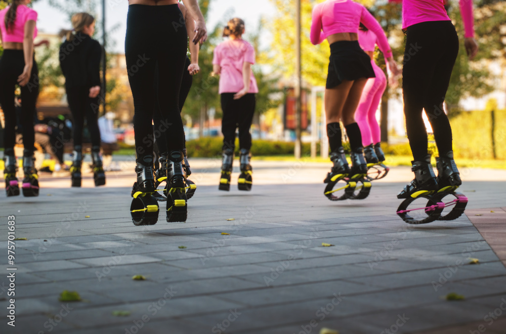 A group of girls are jumping on the street in a city park. A group of girls are jumping on the street in a city park.