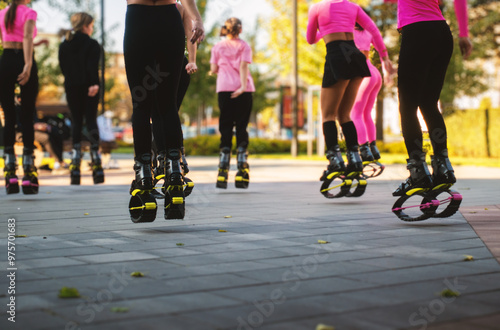 A group of girls are jumping on the street in a city park.