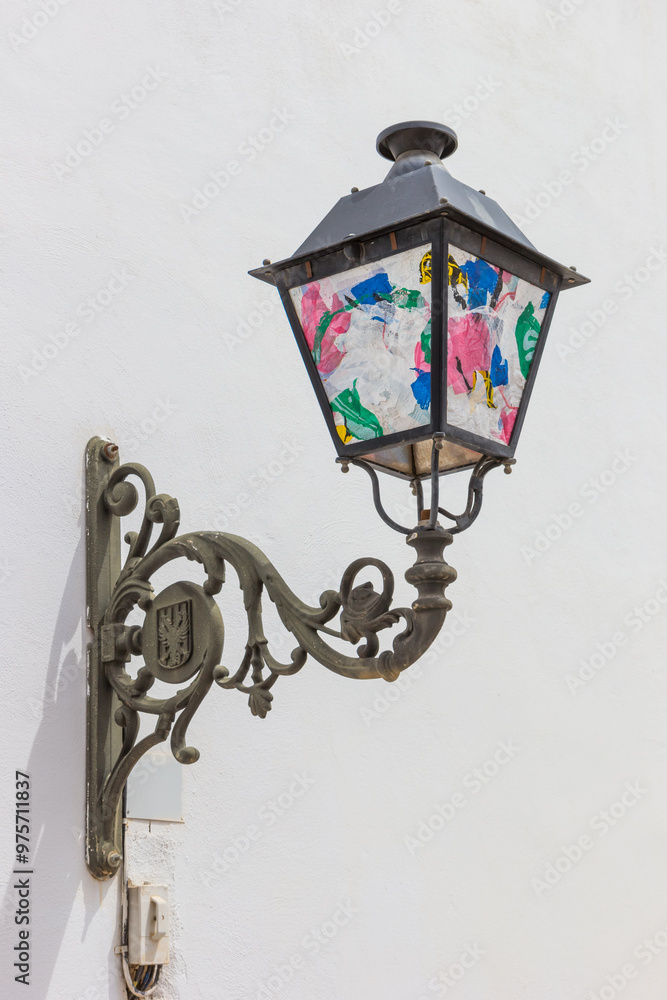Decorated street light on the facade of a white house in Altea, Spain