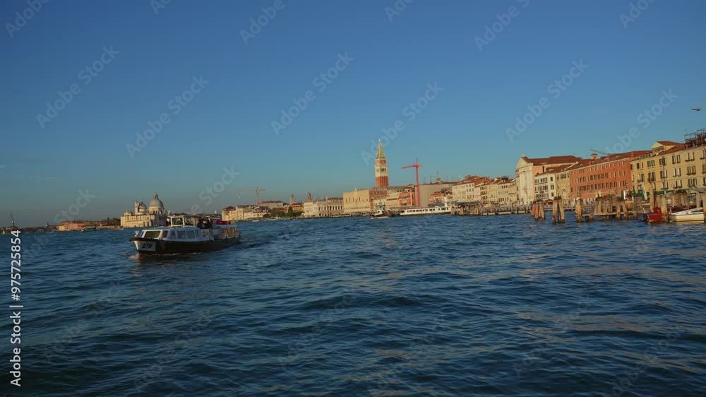 grand canal at sunset with the tower of piazza San Marco and boat in first plane grand canal at sunset with the tower of piazza San Marco and boat in first plane