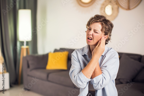 Foto Sick woman having ear pain at home, upset female rubbing sore auricle with hand
