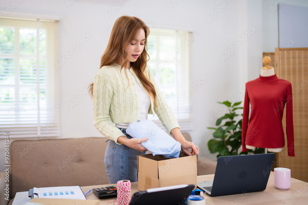 A young woman, working as an online clothing merchant, is preparing packages at her desk. She is surrounded by laptops, boxes, and clothing items in a bright and organized workspace A young woman, working as an online clothing merchant, is preparing packages at her desk. She is surrounded by laptops, boxes, and clothing items in a bright and organized workspace