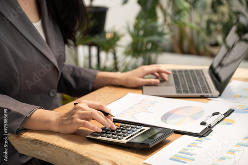 Businesswoman hand holding pen, analysis the graph with laptop at the home office for setting challenging business goals And planning to achieve the new target