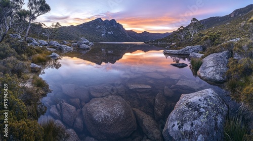 An untouched high mountain lagoon with transparent waters, surrounded by dense pine trees and rocky cliffs. The sky is overcast, adding a moody feel to the scene.