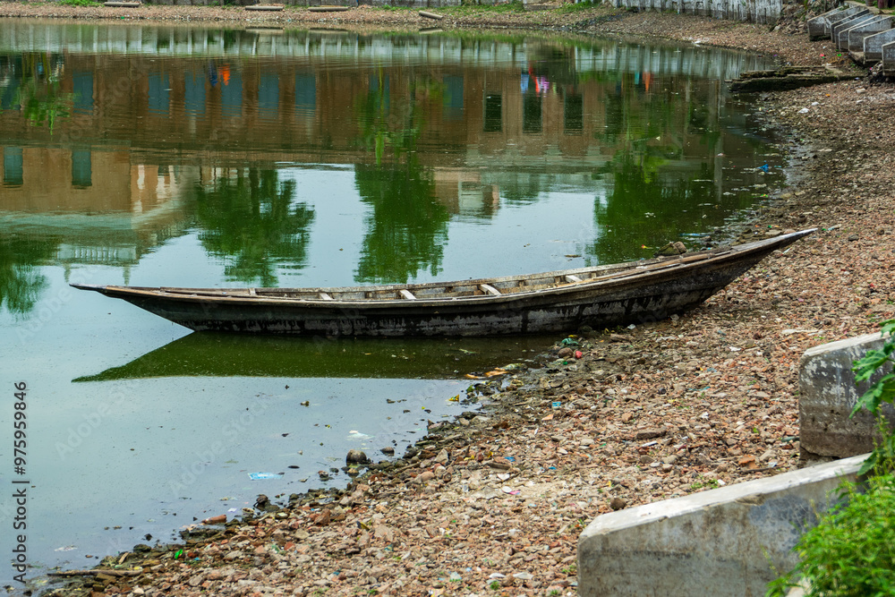 Traditional Bengali Wooden boat on pond bank.