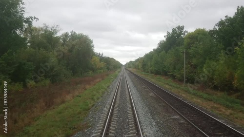 Moving forward on the Russian Railway. The view from the face of the train driver. A summer or autumn cloudy day.