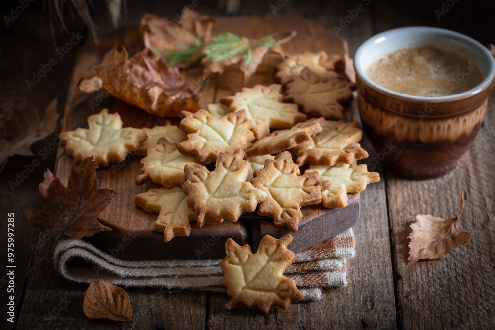 Fototapeta premium Autumn leaf shaped cookies with coffee cup on wooden board, selective focus