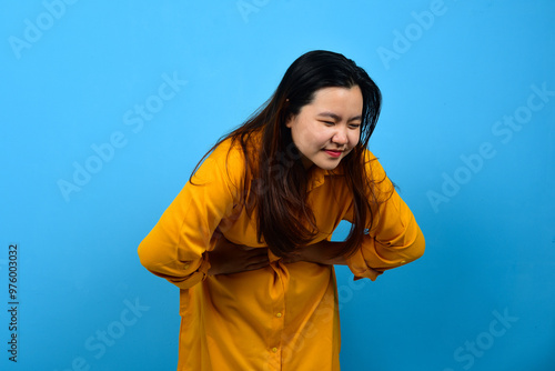 Fotografie A girl of Asian appearance feels pain in her stomach coming period sick isolated