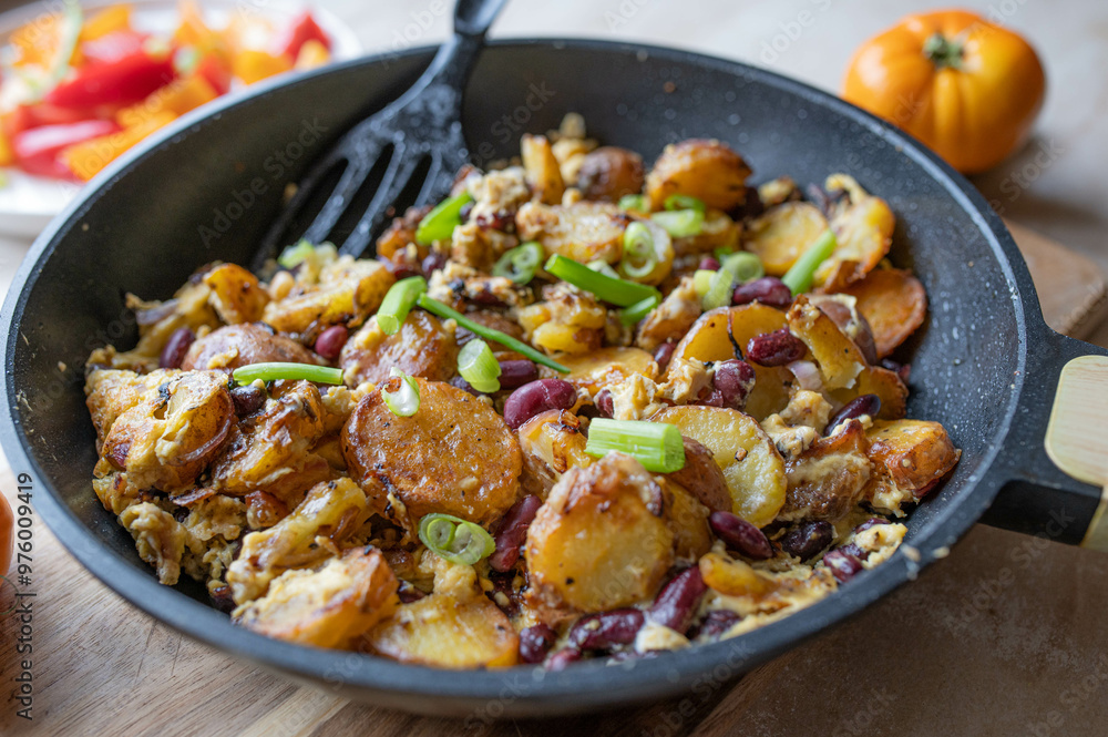 Homemade vegetarian fried potatoes with eggs, onions and kidney beans in a frying pan Homemade vegetarian fried potatoes with eggs, onions and kidney beans in a frying pan