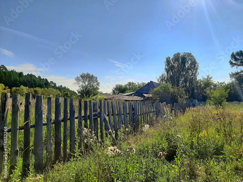 An old wooden fence on the edge of the village. Close-up, selective focus.