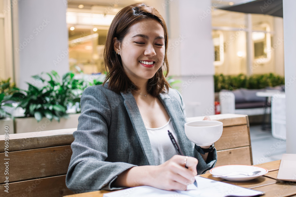 Happy freelancer writing in notebook and drinking coffee Happy freelancer writing in notebook and drinking coffee