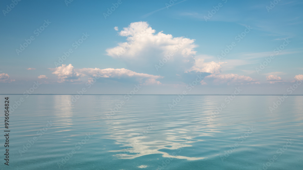 A photo of a clear sky with a few fluffy white clouds. The horizon line separates the sky from the calm, reflective body of water below. The sky and water meet at the horizon line. A photo of a clear sky with a few fluffy white clouds. The horizon line separates the sky from the calm, reflective body of water below. The sky and water meet at the horizon line.