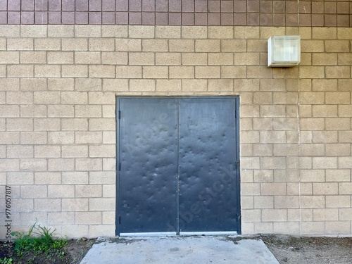 a closed steel back door marks the entrance to a shipping and receiving area, with secure, industrial design and functional features, awaiting shipments and deliveries to be processed efficiently