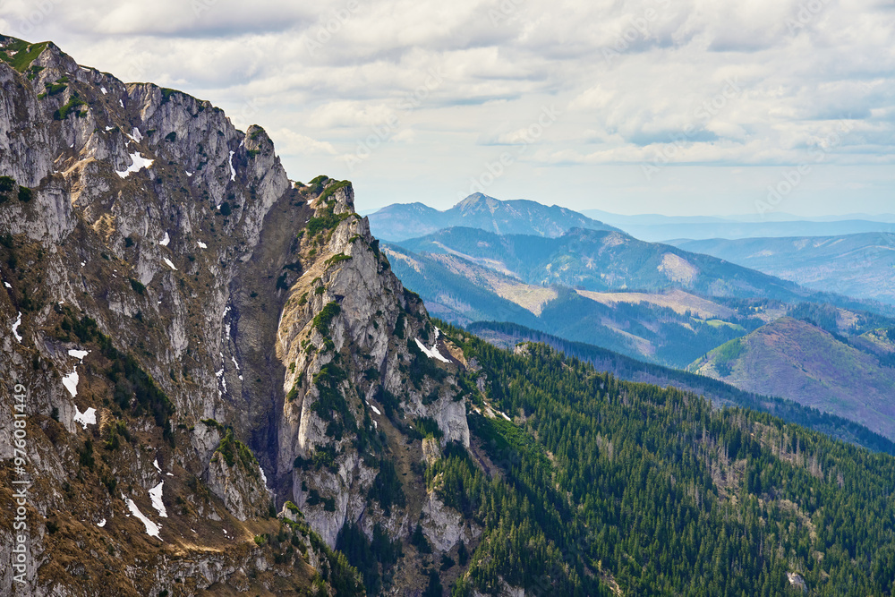 Obraz premium Rugged mountain slope with rocky cliffs and patches of snow. Tatra National Park in Poland. Natural landscape
