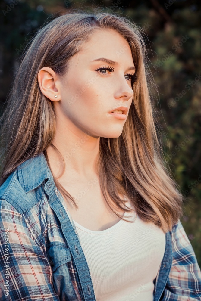 Young blonde female model with natural long hair looking thoughtfully away outdoors Young blonde female model with natural long hair looking thoughtfully away outdoors
