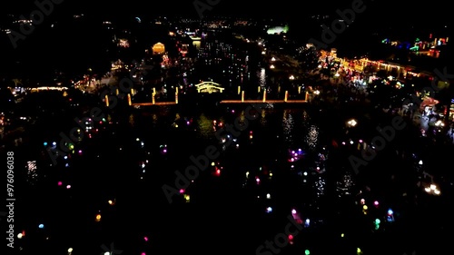 Stunning drone footage captures the tranquil beauty of Hoi An's Old Town historic Unesco heritage site at night, as colorful lantern boats drift along the Thu Bôn River.