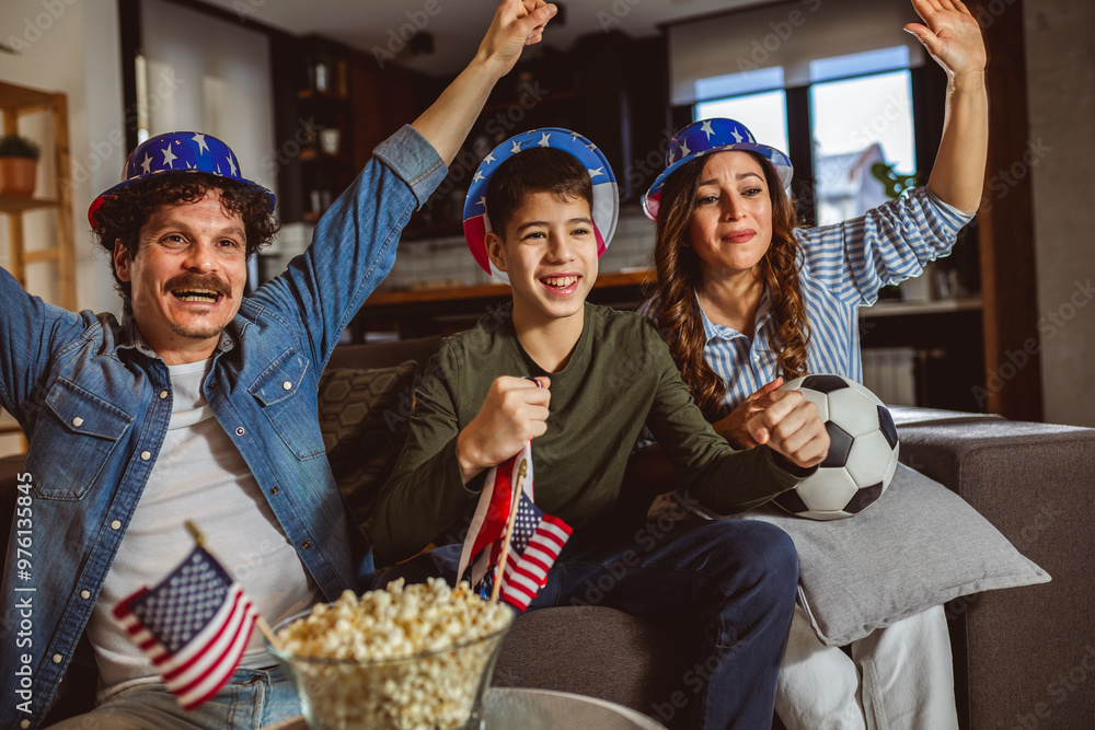 Fototapeta premium Latino family is watching football match with American flags