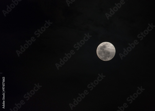 A captivating image of a full moon set against a pitch-black night sky. The detailed surface of the moon stands out, offer a serene and atmospheric feel, perfect for astronomy and night-themed project