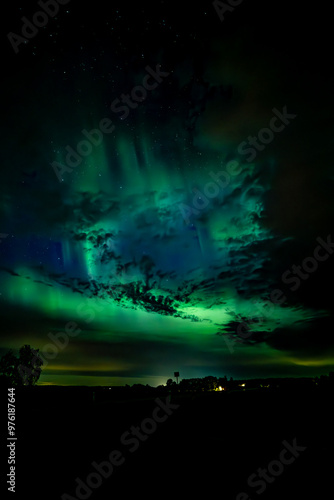 Northern lights dancing over the sky sky in the country road