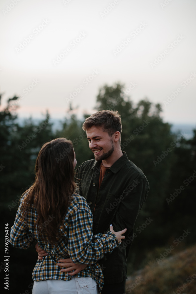 A couple in love embrace while standing on the edge of a cliff at sunset. A couple in love embrace while standing on the edge of a cliff at sunset.