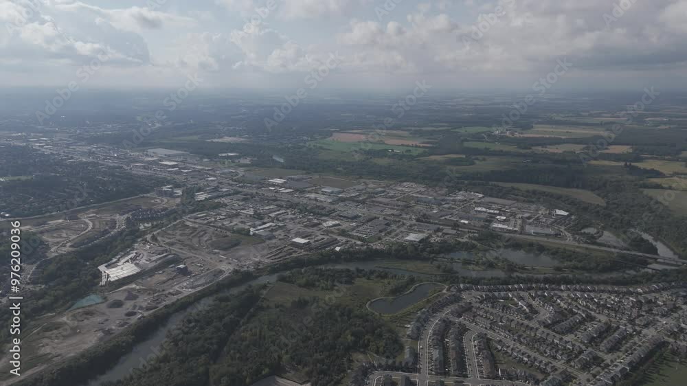 Drone view of the Grand River surrounded by lush trees and cityscape on a sunny day with cloudy sky Drone view of the Grand River surrounded by lush trees and cityscape on a sunny day with cloudy sky