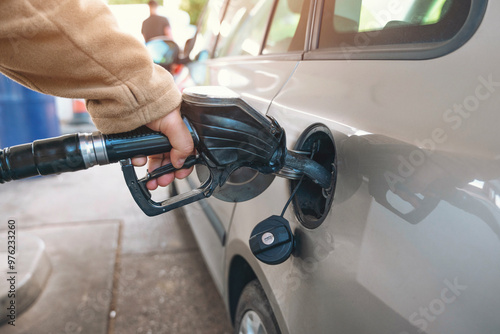 Refueling Silver Car at Gas Station on Sunny Day With People in Background