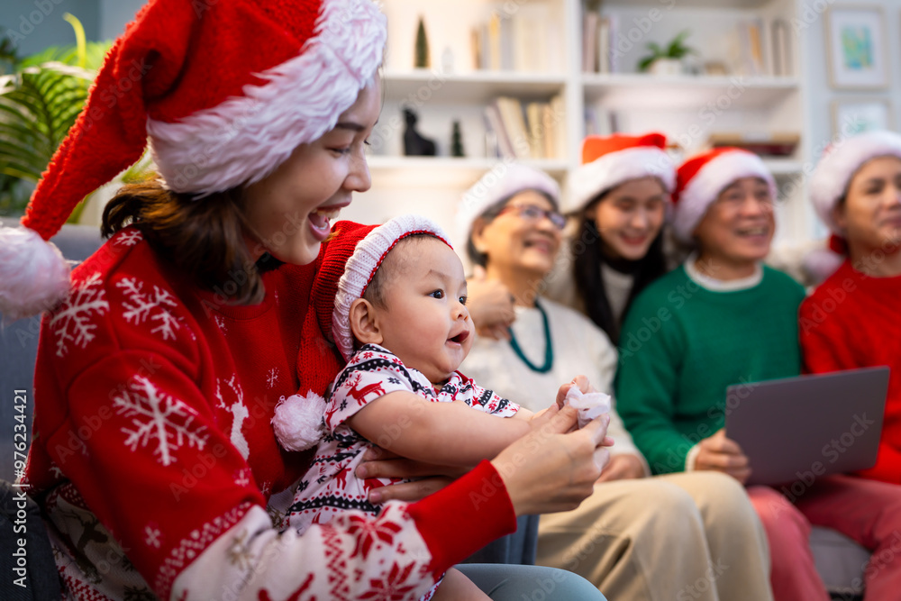 Asian family on Christmas Day. Everyone is happy together in a Christmas themed room filled with presents and orange lights. Asian family on Christmas Day. Everyone is happy together in a Christmas themed room filled with presents and orange lights.
