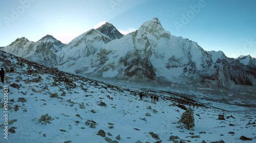 Panoramic view from Kala Patthar mountain of Everest, Lhotse, Nuptse and Ama Dablam mountains at twilight just before the sunrise. People on slope. Hiking in Nepal. Extreme terrain landscapes theme.