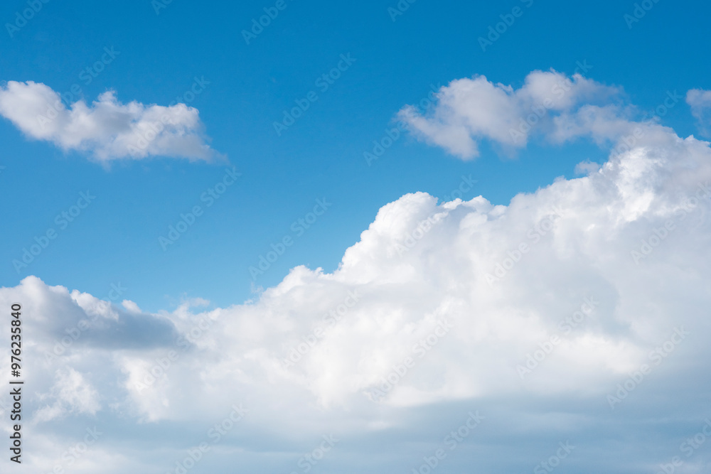 Bright Blue Sky Adorned With Fluffy White Clouds Drifting Lazily Under Midday Sun in Summer Bright Blue Sky Adorned With Fluffy White Clouds Drifting Lazily Under Midday Sun in Summer
