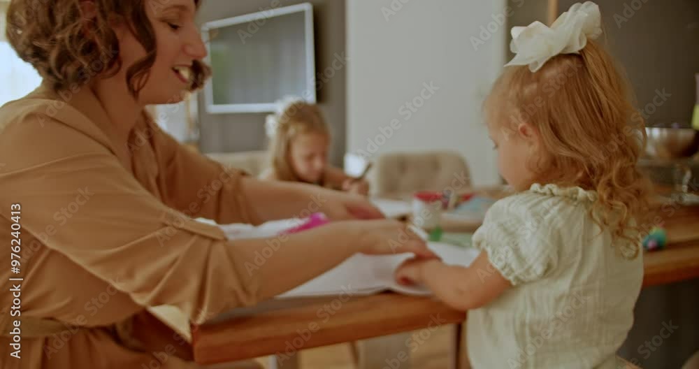 Mother and her two daughters having fun while drawing and crafting at home. Mother and her two daughters having fun while drawing and crafting at home.