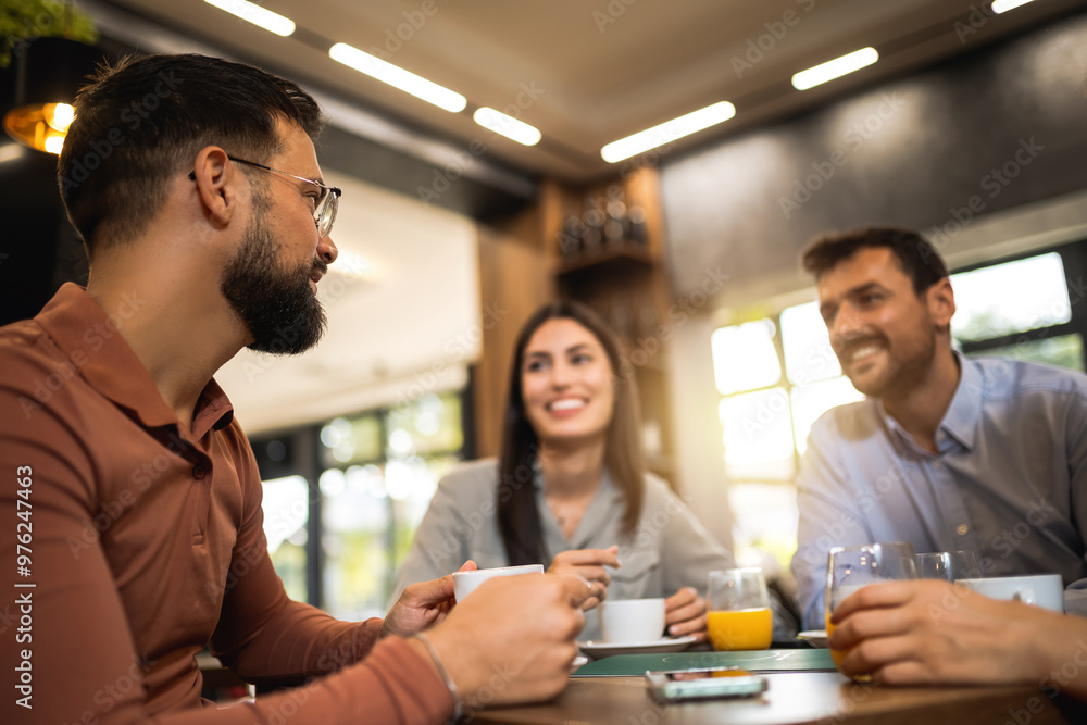 Group of friends laughing together at the coffee shop. They drink orange juice and hang out together. Group of friends laughing together at the coffee shop. They drink orange juice and hang out together.