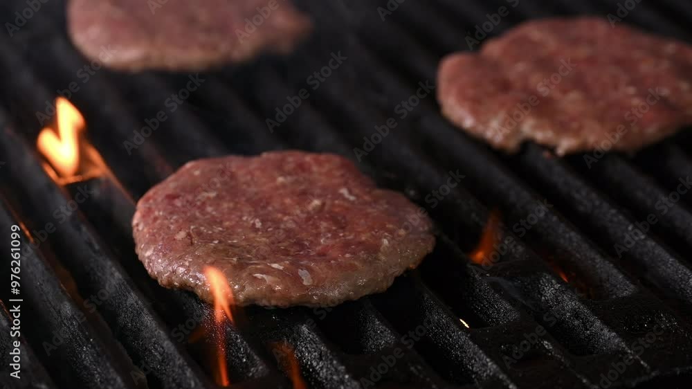 Three hamburgers are cooking on a grill, with the flames licking the edges of the patties. The burgers are browning and sizzling, creating a mouth-watering aroma Three hamburgers are cooking on a grill, with the flames licking the edges of the patties. The burgers are browning and sizzling, creating a mouth-watering aroma