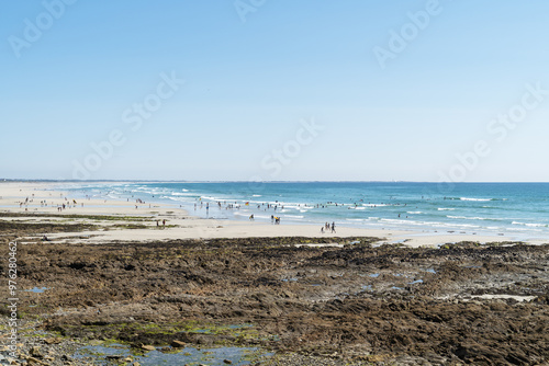 Photography La plage de Penhors en Bretagne, animée par une belle journée d'été, avec de nombreux baigneurs dans l'océan Atlantique et des gens profitant du sable