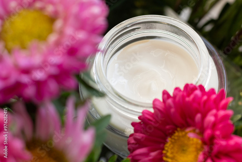 Obraz na płótnie Closeup of a jar of moisturizer surrounded by flowers. Concept of spring skincare. w salonie