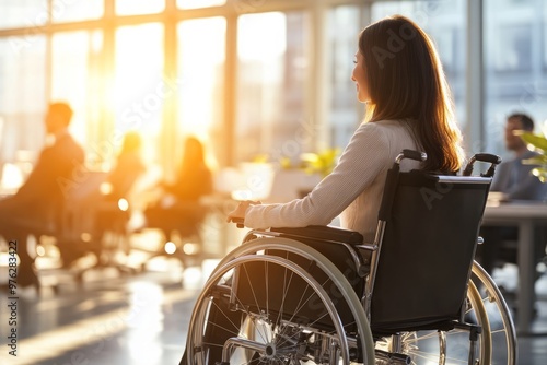 photo of a woman in a wheelchair communicates cheerfully with employees of the office during a business meeting.