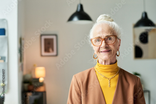 Photos Portrait of elderly woman with white hair, wearing glasses and smiling indoors,