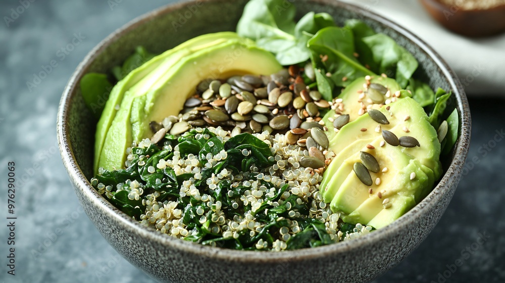 Close-up of a bowl of quinoa with avocado, spinach, and pumpkin seeds. Close-up of a bowl of quinoa with avocado, spinach, and pumpkin seeds.
