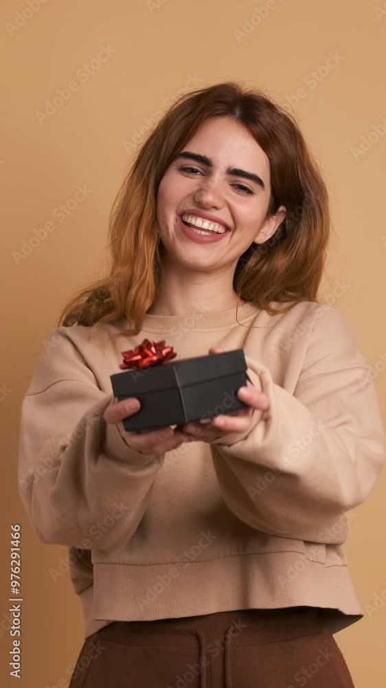 Cheerful young blond woman presenting gift box. Vertical Footage Cheerful young blond woman presenting gift box. Vertical Footage