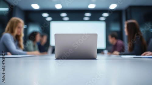 laptop in front table in a meeting room. The room has whiteboards and a large computer monitor