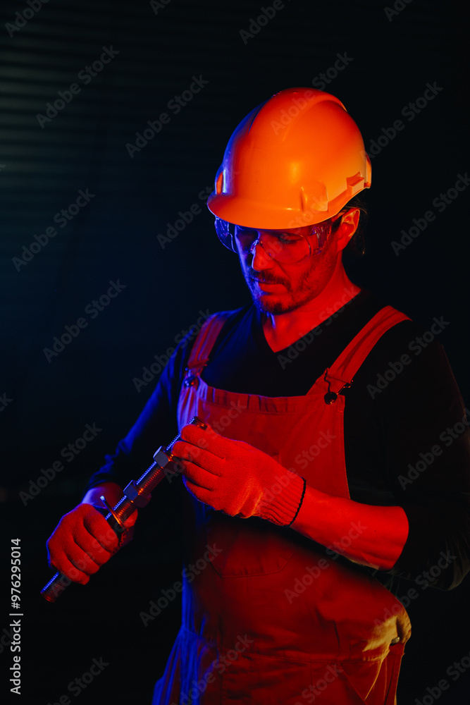 Fototapeta premium The assembly worker is illuminated by red neon light.