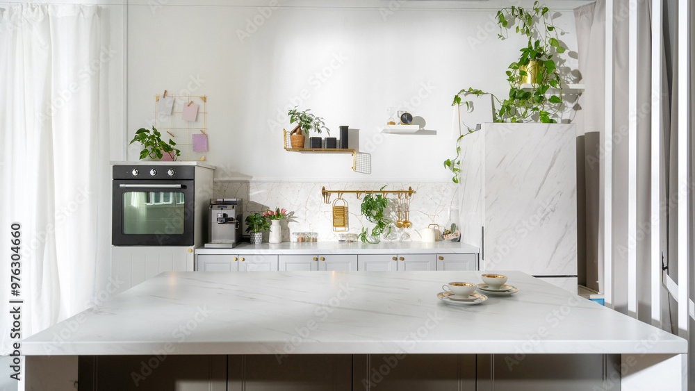 Modern kitchen with marble countertop and greenery, featuring appliances and decorative items in a bright space Modern kitchen with marble countertop and greenery, featuring appliances and decorative items in a bright space