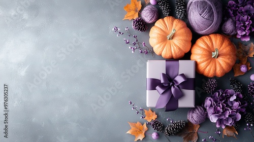   Purple gift box, purple ribbon and bow, purple flowers and pumpkins on gray background