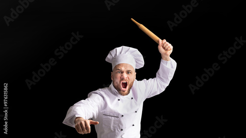 Angry Chef Bakerman Raising Rolling Pin Threateningly Posing Over Black Background. Studio Shot photo