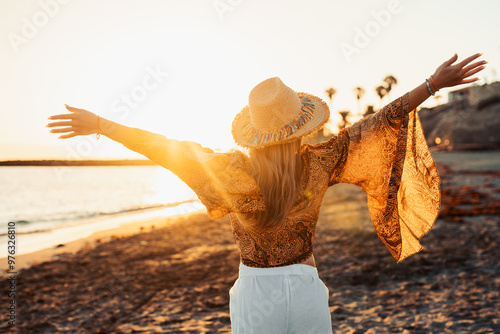 One happy beautiful woman walking on the sand of the beach enjoying and having fun at the sunset of the day. Leisure time on vacations, freedom concept. #976326810